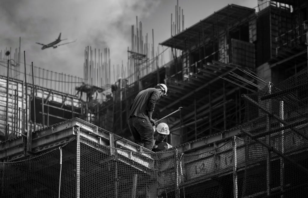 Black and white photo showing construction workers on an urban building site.