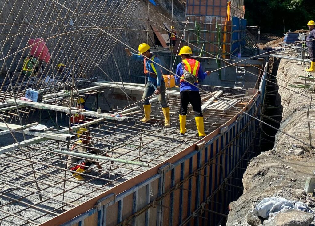 Workers busy at a sunlit construction site in Surakarta, Central Java, Indonesia.
